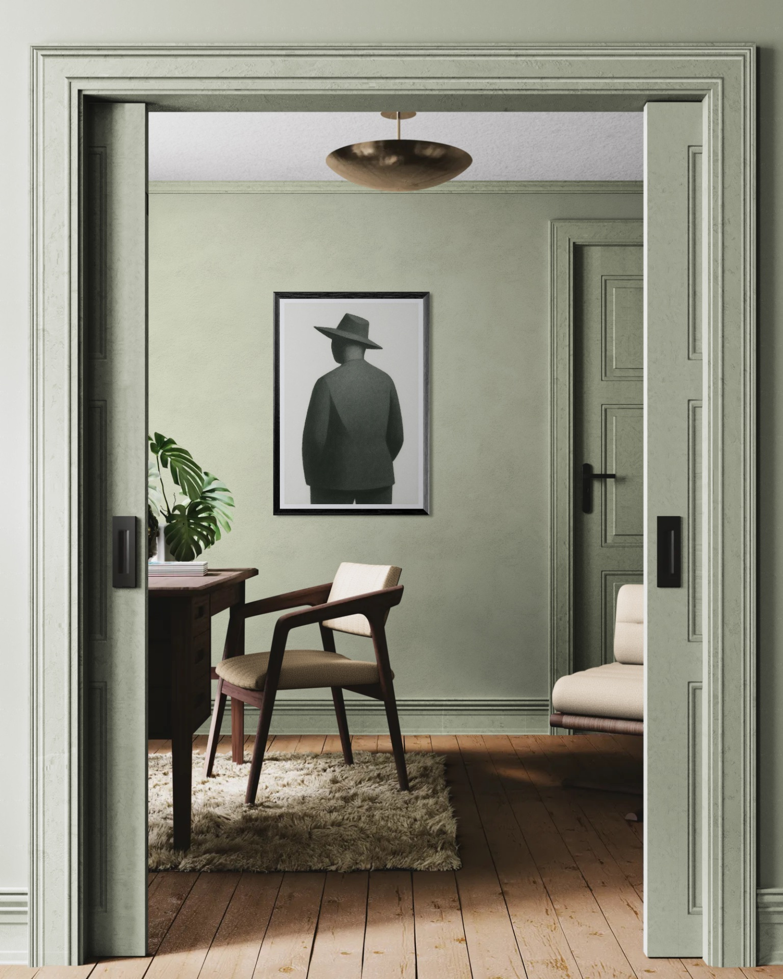 Room with a framed picture of an abstracted man in a hat on the wall, a chair, and a desk.