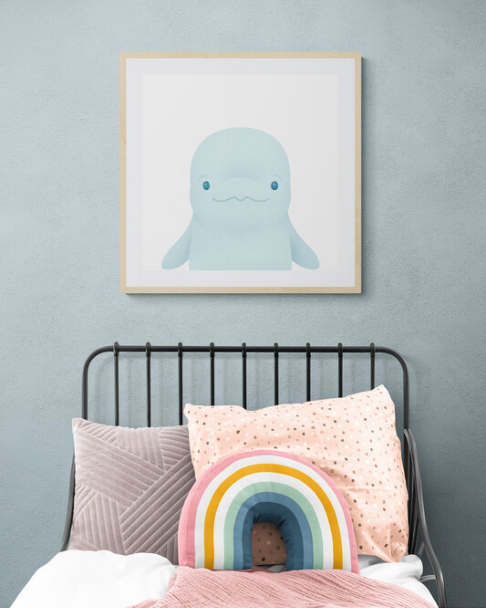 Children's bedroom with a bed featuring colorful pillows and a framed illustration of a beluga whale on the wall.
