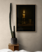 Framed artwork of a candle on a wall next to a cactus plant.
