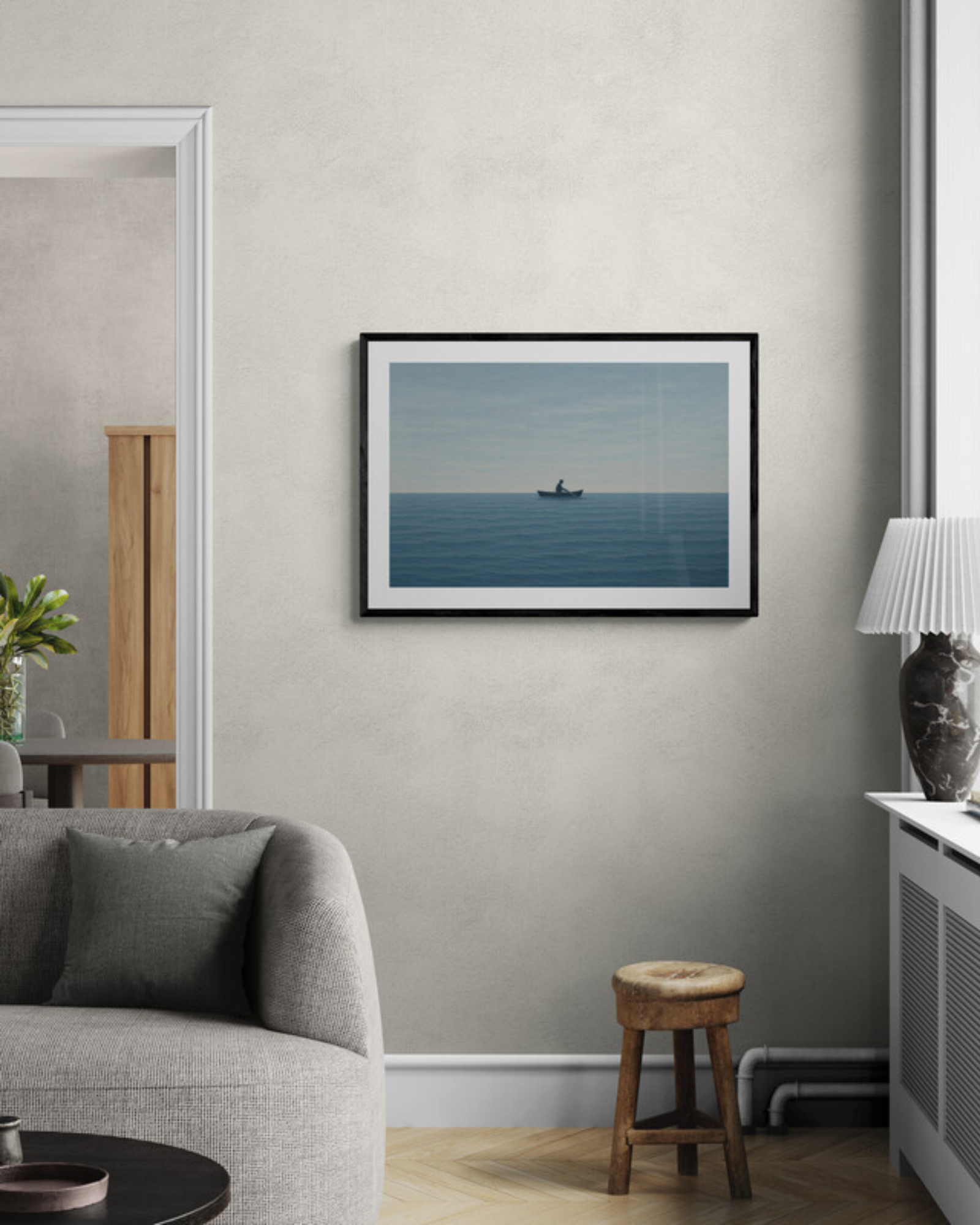 Framed artwork of a boat on water in a living room setting.