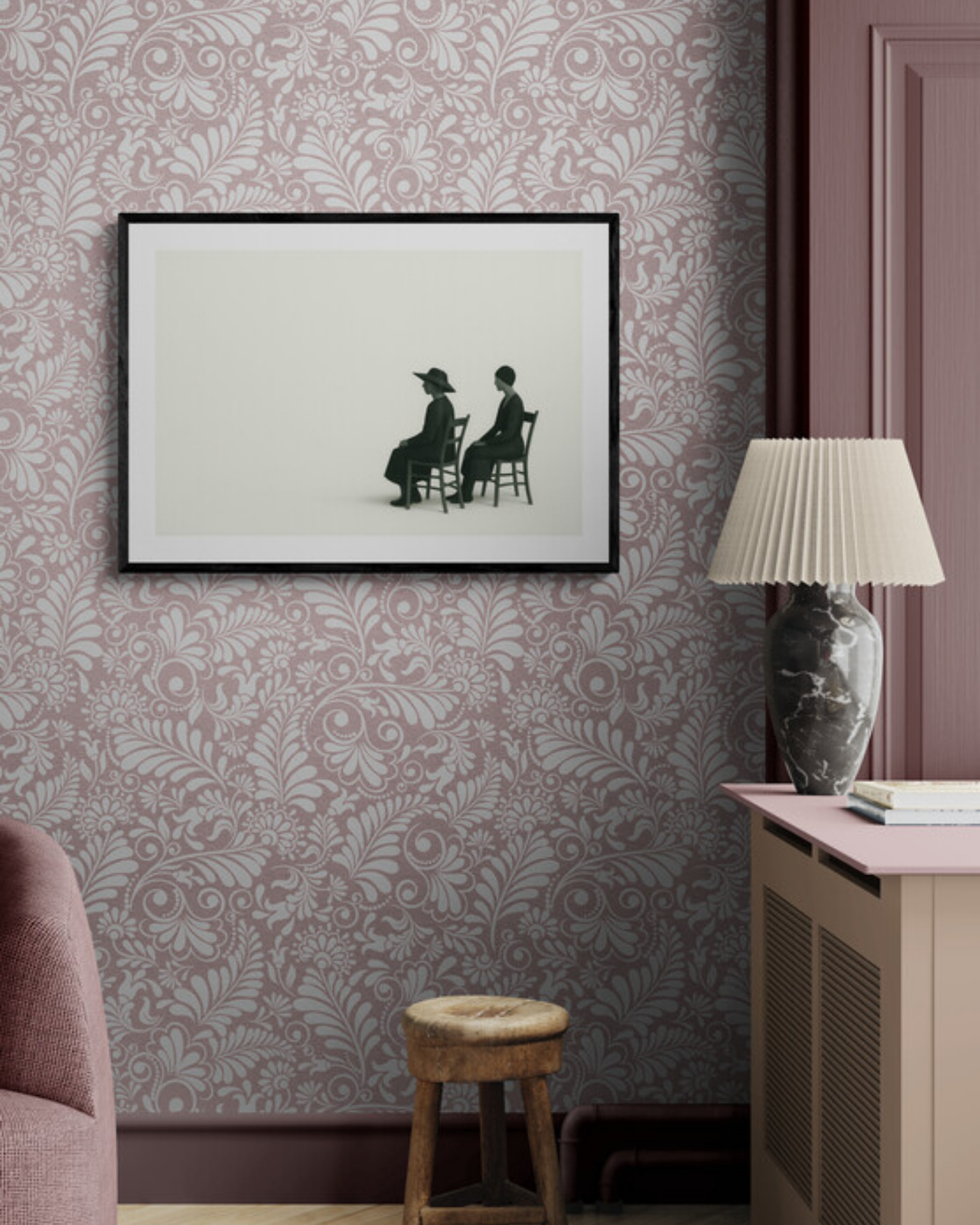 Framed black and white artwork on a wall with decorative wallpaper and furniture.