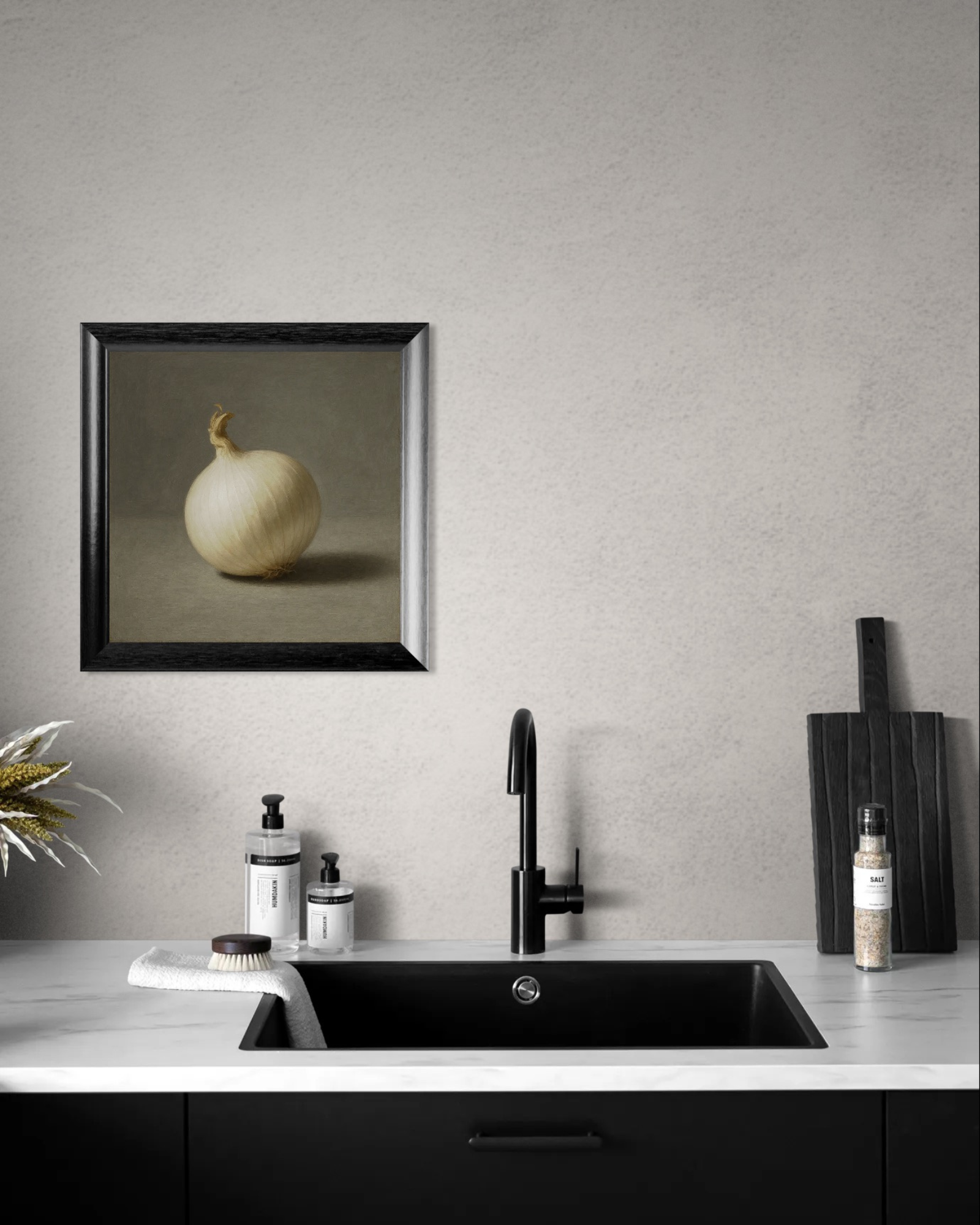 Modern kitchen with black faucet, countertop, and framed artwork of a white onion on gray wall.