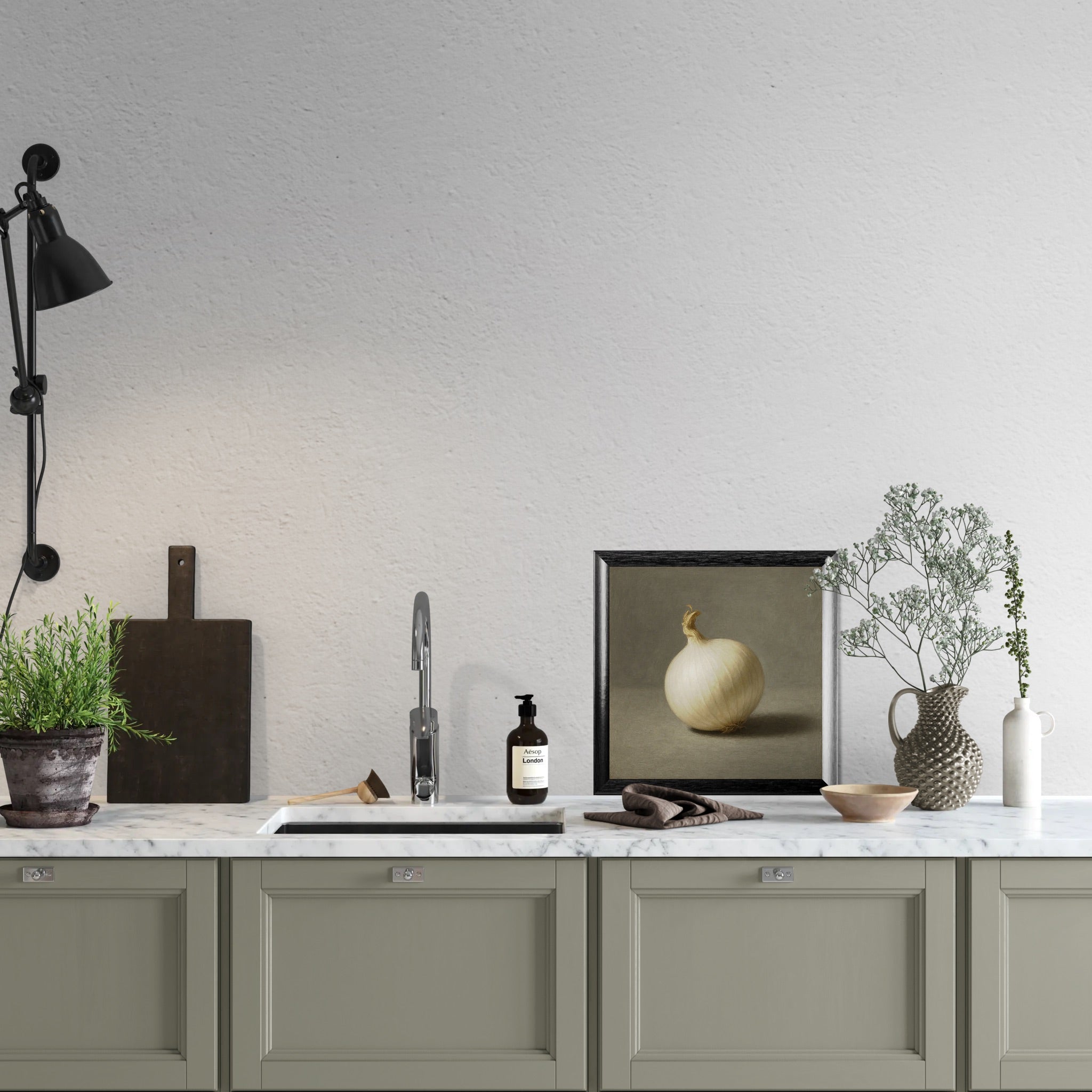 Modern kitchen with marble countertop, sink, and frame print of a white onion