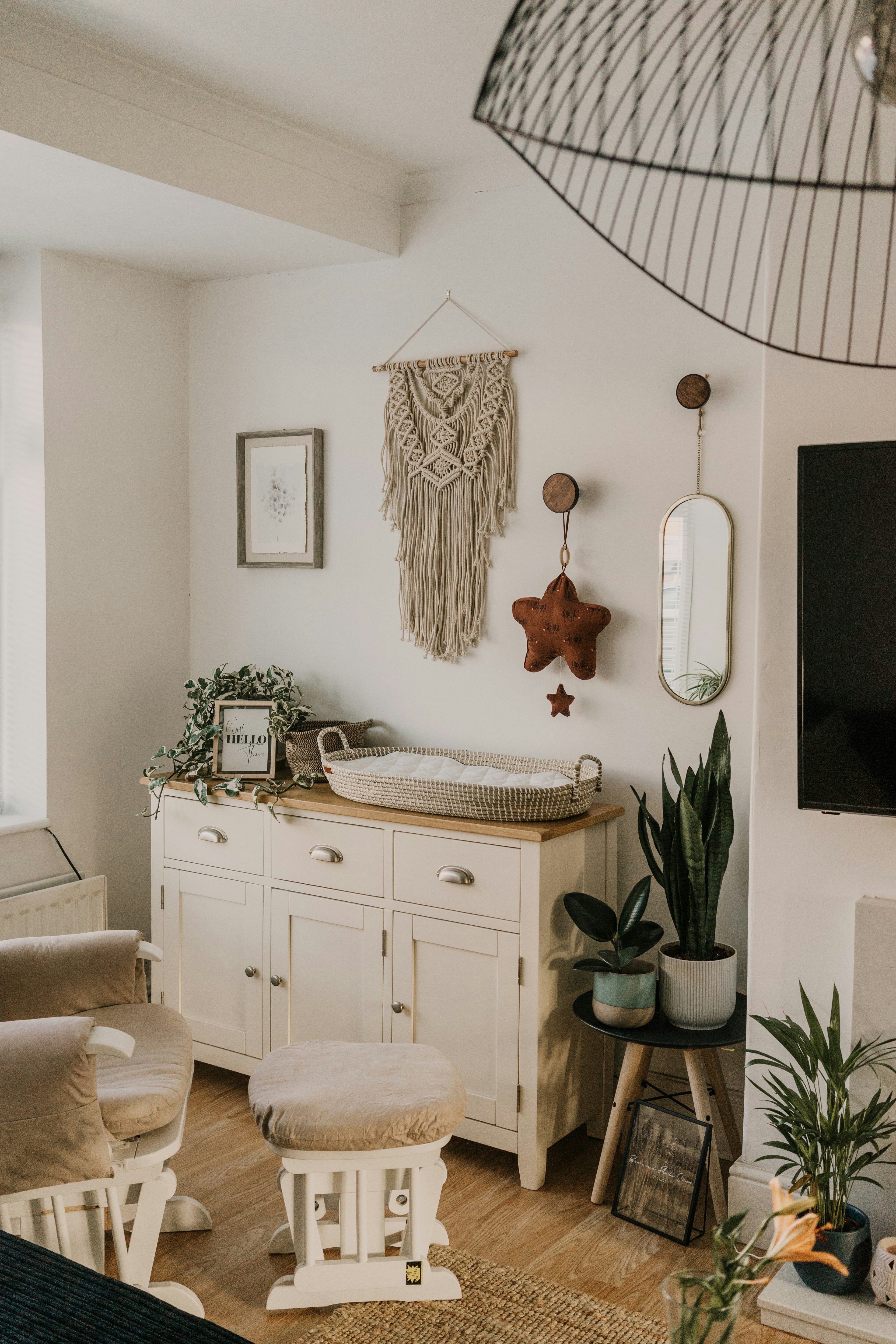 Gender neutral toddler room with wall art,  white dresser, decorative items, and plants.